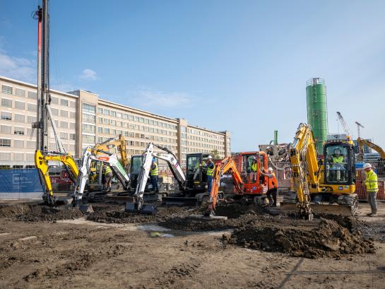 Medewerkers besturen de graafmachines